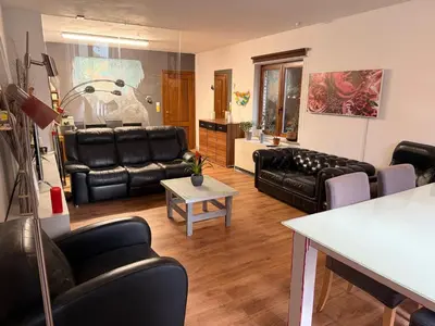 a living room with black leather furniture and a table at Perk25A in Steenokkerzeel