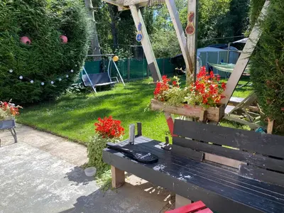 a park bench with flowers in a garden at Perk25A in Steenokkerzeel