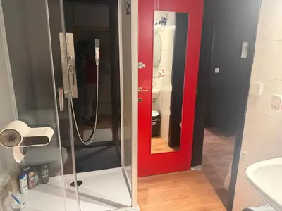 a bathroom with a shower with a mirror and a sink at Perk25A in Steenokkerzeel