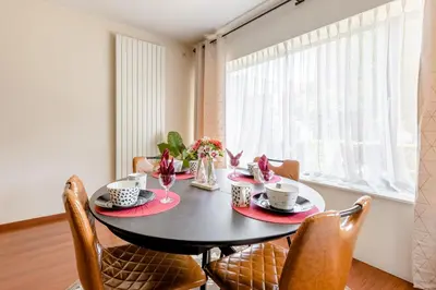 a dining room with a black table and chairs at Luxe apt with parking & garden in wilrijk antwerp in Antwerp