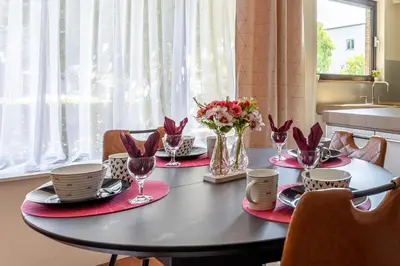 a dining room table with red napkins and flowers on it at Luxe apt with parking & garden in wilrijk antwerp in Antwerp