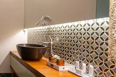 a bathroom with a sink and a mosaic wall at Luxe apt with parking & garden in wilrijk antwerp in Antwerp
