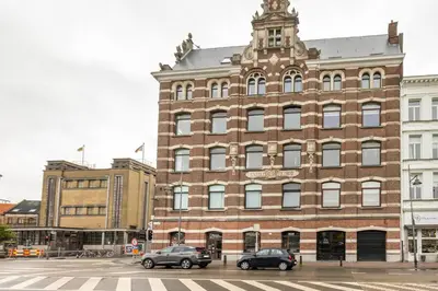 a large brick building with cars parked in front of it at Riverview Studio in Historical Heart of Antwerp in Antwerp
