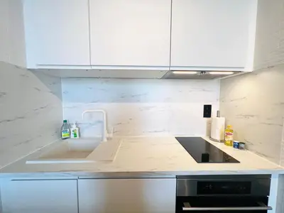 a kitchen with white cabinets and a sink at Riverview Studio in Historical Heart of Antwerp in Antwerp
