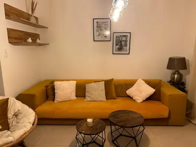 a living room with a yellow couch and two tables at Vintage dream in Heide