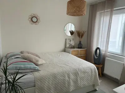 a white bedroom with a bed and a mirror at Vintage dream in Heide