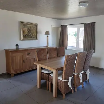 a dining room with a wooden table and chairs at Vakantiewoning Op Den Briel in Lokeren