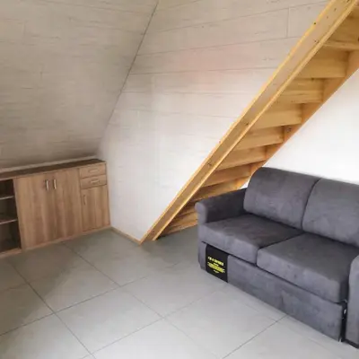 a living room with a couch and a staircase at Vakantiewoning Op Den Briel in Lokeren