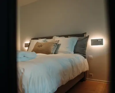 a bedroom with a bed with white sheets and pillows at B&B De Tiendeschuur in Evergem
