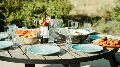 a table with plates of food and a bottle of wine at B&B De Tiendeschuur in Evergem