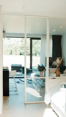 a living room with a large mirror and furniture at B&B De Tiendeschuur in Evergem