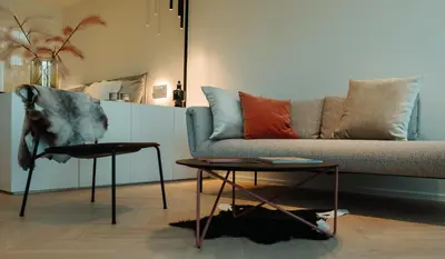 a living room with a couch and a table at B&B De Tiendeschuur in Evergem