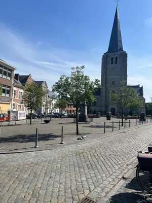 a cobblestone street in front of a church at Rooftop terrace suite in Heist-op-den-Berg