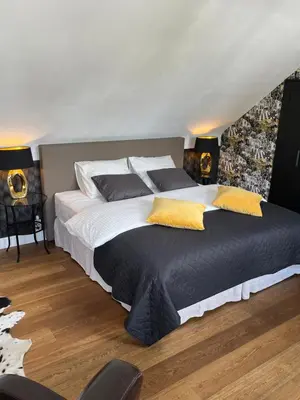 a bedroom with a large bed with yellow pillows at Rooftop terrace suite in Heist-op-den-Berg