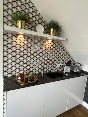 a kitchen with a sink and a wall with clocks at Rooftop terrace suite in Heist-op-den-Berg