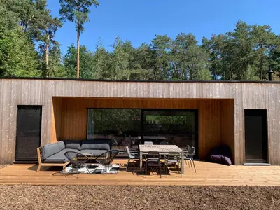 a patio with a couch and a table and chairs at Osbos chalets in Lille