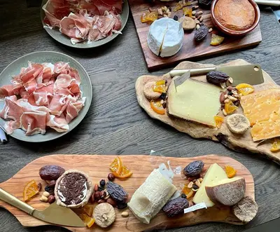 a table topped with plates of cheese and other foods at Osbos chalets in Lille