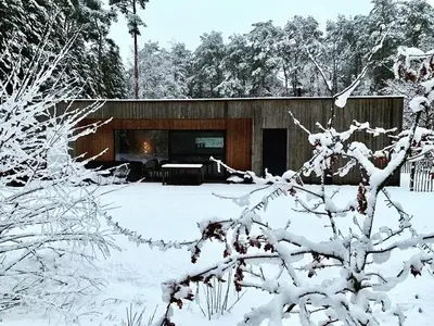 a house with a fireplace in the snow at Osbos chalets in Lille