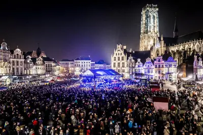 a large group of people standing in a city at night at Huis ALNA 2 in Mechelen