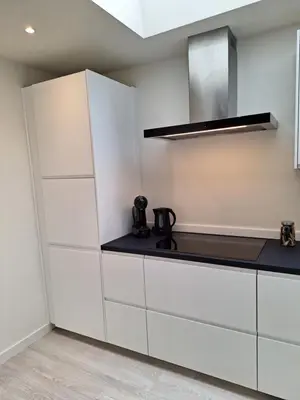 a kitchen with white cabinets and a stove at Huis ALNA 2 in Mechelen