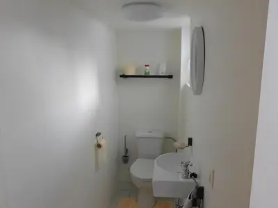 a white bathroom with a toilet and a sink at Vakantiewoning Louis in Mechelen