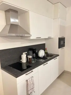 a kitchen with white cabinets and a counter top at Hote Brussels center City luxe Tours et Taxi in Brussels