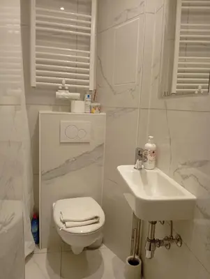 a white bathroom with a toilet and a sink at Benny's Rooms Brussels City Centre in Brussels