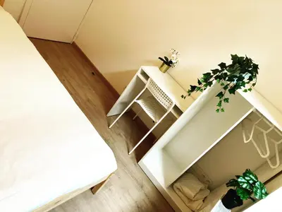 a room with a bed and a white shelf with a plant at Benny's Rooms Brussels City Centre in Brussels