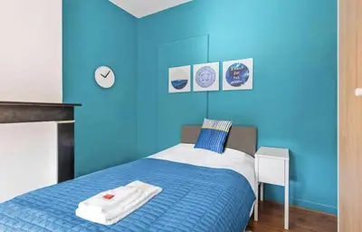 a blue bedroom with a bed with towels on it at The Old One Fifteen by Romy&Travis in Ghent