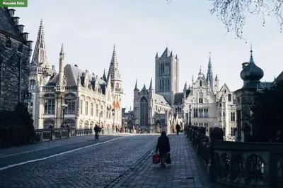 a person walking down a cobblestone street with buildings at The Old One Fifteen by Romy&Travis in Ghent