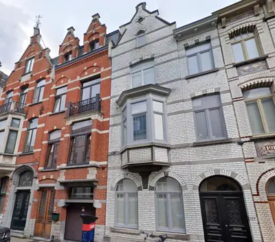 a large brick building with windows on a street at The Old One Fifteen by Romy&Travis in Ghent