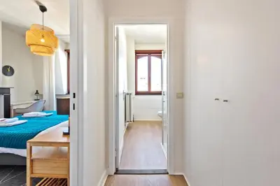 a corridor of a room with a bed and a table at The Old One Fifteen by Romy&Travis in Ghent