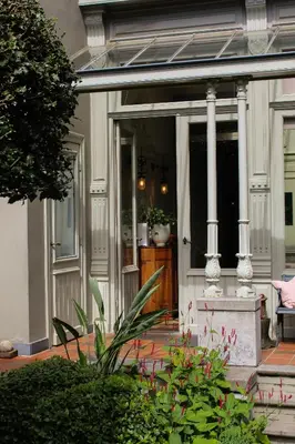 a front porch of a house with columns and flowers at Huis Dujardin Bed&Breakfast in Antwerp
