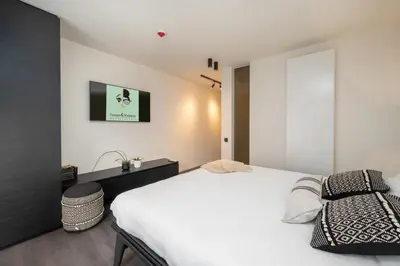 a bedroom with a white bed and a window at Georges & Madeleine Apartments in Aalst