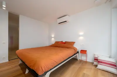 a bedroom with a bed with an orange blanket at Georges & Madeleine Apartments in Aalst