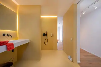 a bathroom with yellow walls and a sink and a shower at Georges & Madeleine Apartments in Aalst