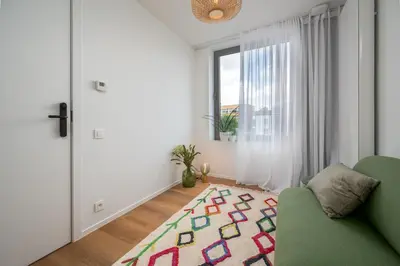 a living room with a green couch and a window at Georges & Madeleine Apartments in Aalst