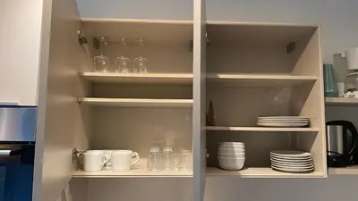 a cupboard with plates and cups and dishes in it at Oneluxstay Antwerp City Centre in Antwerp