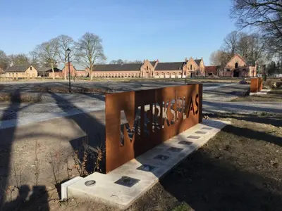 a bench sitting in the middle of a parking lot at B&B De Grote Plaats in Hoogstraten