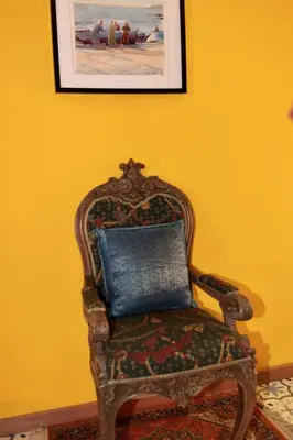 a chair with a blue pillow in a yellow room at B&B Allegra Nova in Ghent