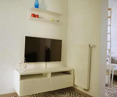 a living room with a television on a white wall at B&B Allegra Nova in Ghent