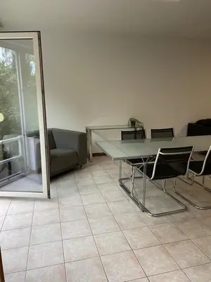 a room with a table and chairs and a couch at Superbe appartement lumineux et spacieux in Antwerp