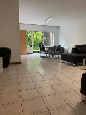 a living room with couches and a table and chairs at Superbe appartement lumineux et spacieux in Antwerp