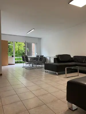 a living room with a couch and tables and chairs at Superbe appartement lumineux et spacieux in Antwerp