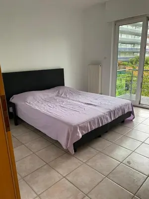 a bedroom with a bed in a room with a window at Superbe appartement lumineux et spacieux in Antwerp