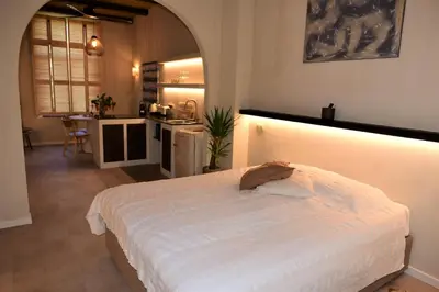 a bedroom with a white bed and a kitchen at Sabi Stay Antwerp in Antwerp