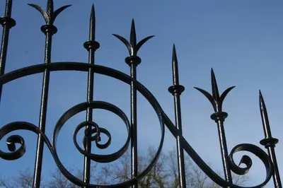 a black iron fence with a blue sky in the background at B&B Hippo-Droom in Hoeilaart