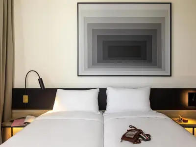 two beds in a hotel room with a picture on the wall at ibis Brussels Groot Bijgaarden in Groot-Bijgaarden