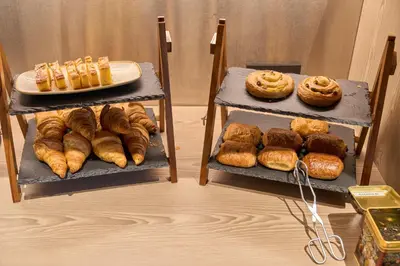 two shelves with different types of bread and pastries at ibis Brussels Groot Bijgaarden in Groot-Bijgaarden