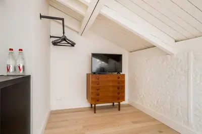 a living room with a tv and a wooden dresser at Quartier Le Sud in Antwerp